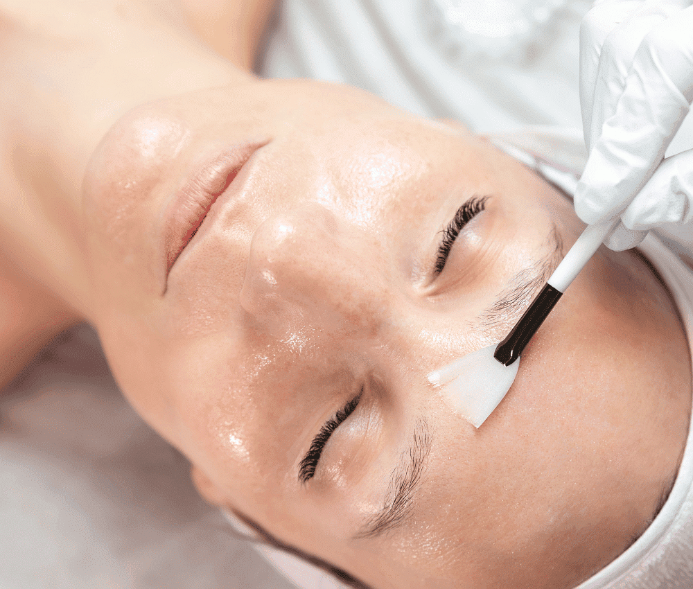 Person receiving a facial treatment with a brush.