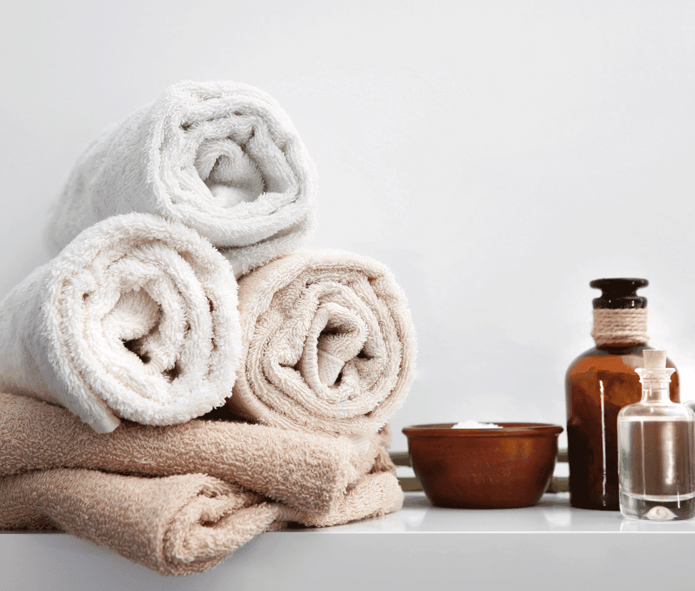 Rolled towels with toiletries on a white background.